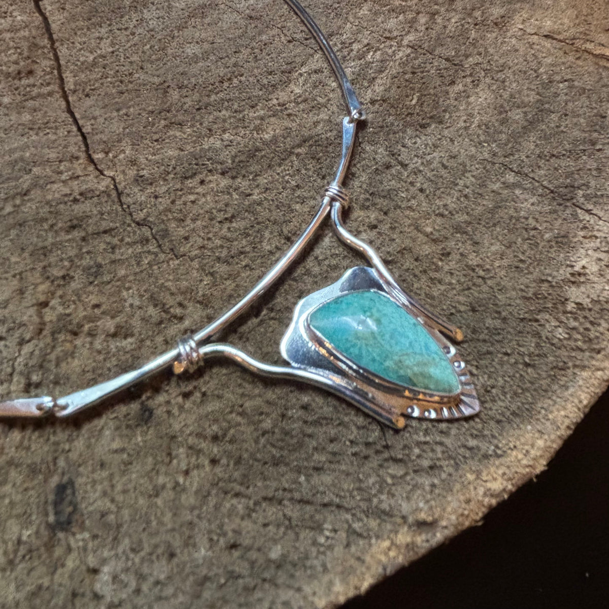 Sterling silver and turquoise neck collar on a wood background
