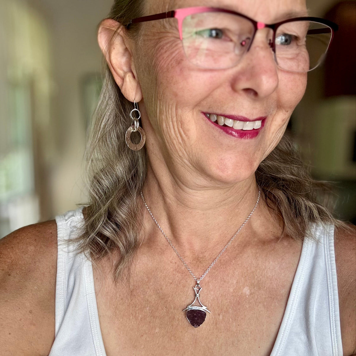 Woman in a white tank top wearing glasses and a handmade sterling silver druzy amethyst necklace 